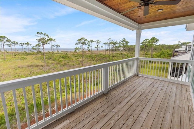 deck with a ceiling fan and a water view