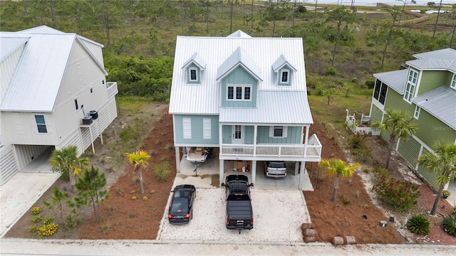 view of front of property featuring a carport, dirt driveway, and metal roof