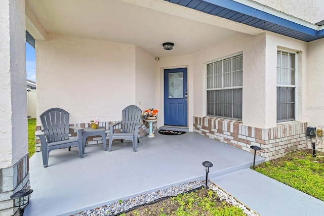 property entrance with a patio area and stucco siding
