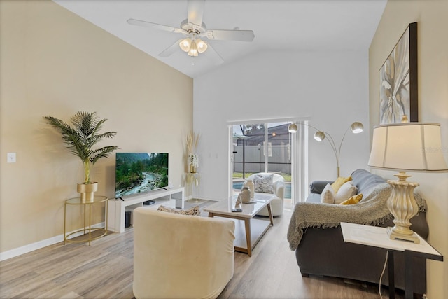 living room with baseboards, wood finished floors, a ceiling fan, and high vaulted ceiling