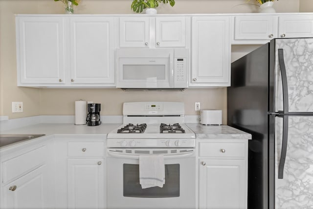 kitchen with white cabinets, light countertops, and white appliances