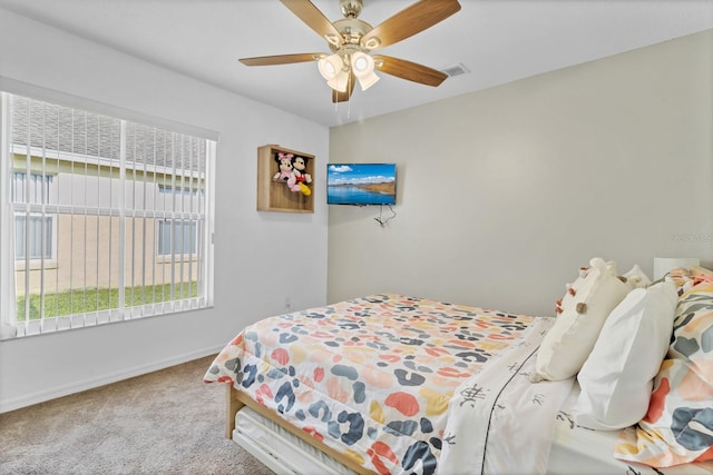 carpeted bedroom with baseboards, a ceiling fan, multiple windows, and visible vents