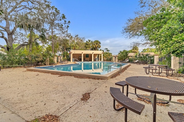 community pool with fence and a patio