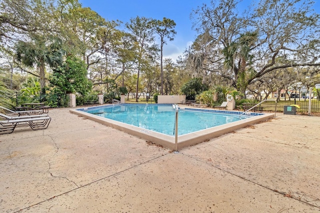 pool featuring fence and a patio