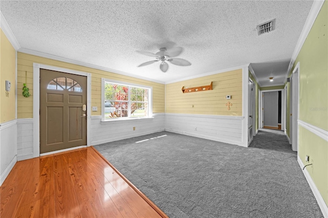 2430 Mill Run Blvd, Kissimmee, FL 34744 - entrance foyer featuring ceiling fan, ornamental molding, wood walls, wainscoting, and a textured ceiling