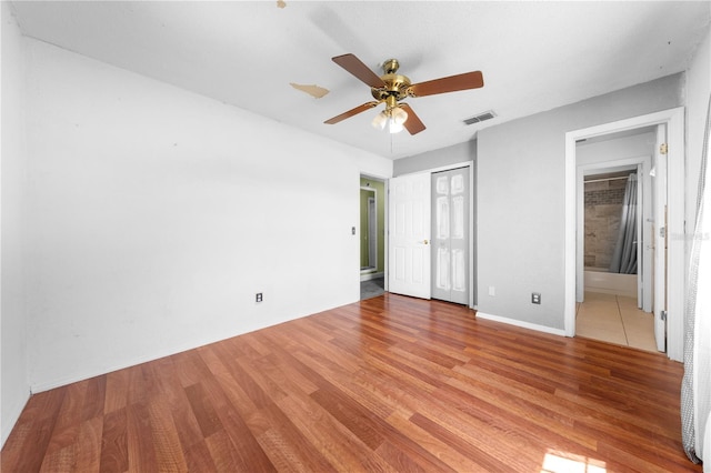 2430 Mill Run Blvd, Kissimmee, FL 34744 - unfurnished bedroom featuring light wood-style floors, ensuite bathroom, baseboards, and a ceiling fan