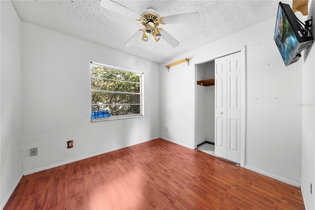 2430 Mill Run Blvd, Kissimmee, FL 34744 - unfurnished bedroom featuring wood finished floors, a textured ceiling, a closet, a ceiling fan, and baseboards