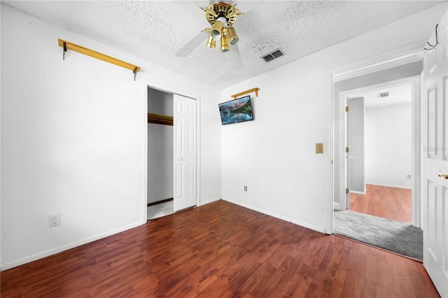 2430 Mill Run Blvd, Kissimmee, FL 34744 - unfurnished bedroom featuring wood finished floors, a textured ceiling, ceiling fan, baseboards, and a closet