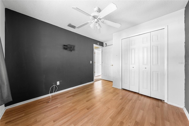 2430 Mill Run Blvd, Kissimmee, FL 34744 - unfurnished bedroom with light wood-style flooring, a closet, a ceiling fan, a textured ceiling, and baseboards