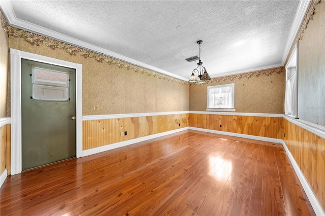 2430 Mill Run Blvd, Kissimmee, FL 34744 - empty room featuring a textured ceiling, hardwood / wood-style floors, a chandelier, ornamental molding, and baseboards