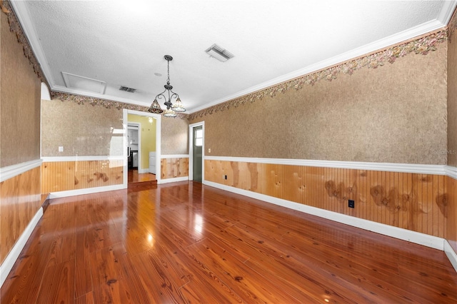 2430 Mill Run Blvd, Kissimmee, FL 34744 - unfurnished room with a chandelier, wood finished floors, a wainscoted wall, crown molding, and a textured ceiling