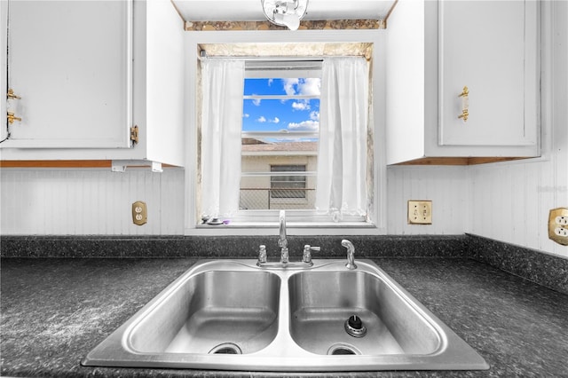 2430 Mill Run Blvd, Kissimmee, FL 34744 - kitchen view of a sink, dark countertops, and white cabinetry
