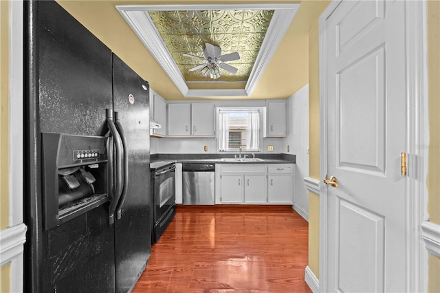 2430 Mill Run Blvd, Kissimmee, FL 34744 - kitchen with black appliances, ceiling fan, a tray ceiling, an ornate ceiling, and dark countertops