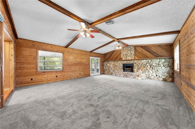 2430 Mill Run Blvd, Kissimmee, FL 34744 - unfurnished living room featuring wooden walls, a ceiling fan, plenty of natural light, a textured ceiling, and carpet flooring