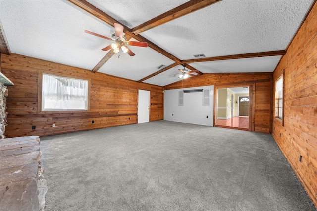2430 Mill Run Blvd, Kissimmee, FL 34744 - unfurnished living room with wooden walls, ceiling fan, plenty of natural light, a textured ceiling, and carpet flooring
