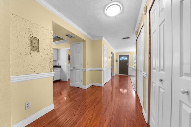 2430 Mill Run Blvd, Kissimmee, FL 34744 - hallway featuring a textured ceiling, wood finished floors, ornamental molding, and baseboards