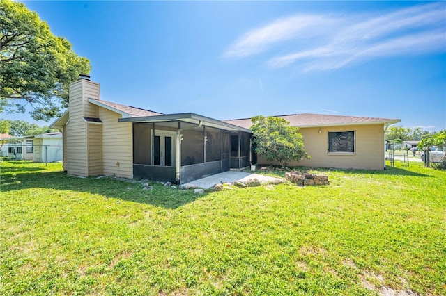 2430 Mill Run Blvd, Kissimmee, FL 34744 - rear view of property with a sunroom, an outdoor fire pit, a chimney, and roof with shingles