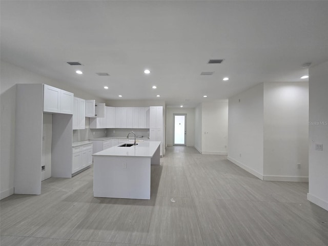 4098 New Milford St, North Port, FL 34288 - kitchen with a sink, baseboards, an island with sink, white cabinetry, and recessed lighting