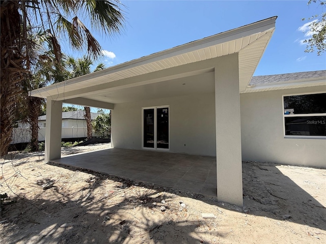 4098 New Milford St, North Port, FL 34288 - rear view of house with stucco siding and a patio