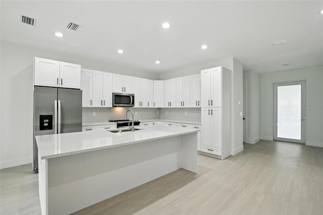 4098 New Milford St, North Port, FL 34288 - kitchen featuring stainless steel appliances, white cabinetry, a kitchen island with sink, and recessed lighting