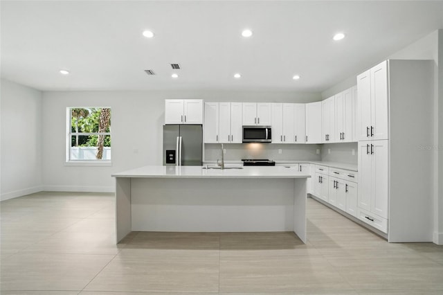 4098 New Milford St, North Port, FL 34288 - kitchen with appliances with stainless steel finishes, a center island with sink, light countertops, white cabinetry, and recessed lighting