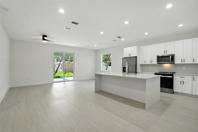4098 New Milford St, North Port, FL 34288 - kitchen with appliances with stainless steel finishes, light countertops, a kitchen island with sink, open floor plan, and white cabinets