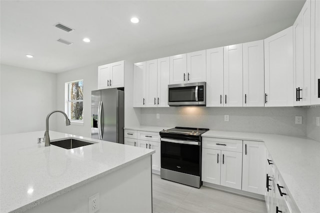 4098 New Milford St, North Port, FL 34288 - kitchen with stainless steel appliances, light stone countertops, white cabinetry, and recessed lighting