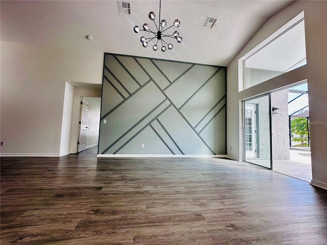 unfurnished living room with a textured ceiling, wood finished floors, visible vents, and a notable chandelier