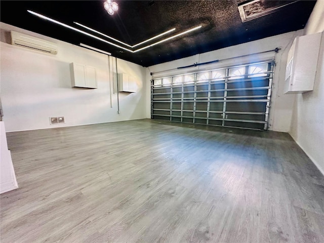 garage with visible vents and an AC wall unit