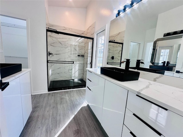 bathroom featuring vanity, wood finished floors, and a marble finish shower