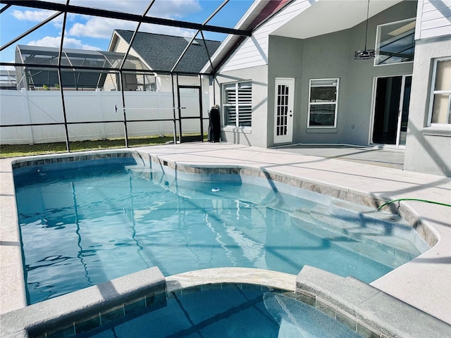 view of swimming pool with a lanai, fence, a patio, and a pool with connected hot tub