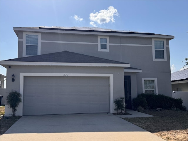 traditional-style home with a garage, stucco siding, and driveway