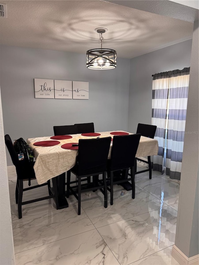 dining room featuring baseboards, visible vents, a textured ceiling, and marble finish floor