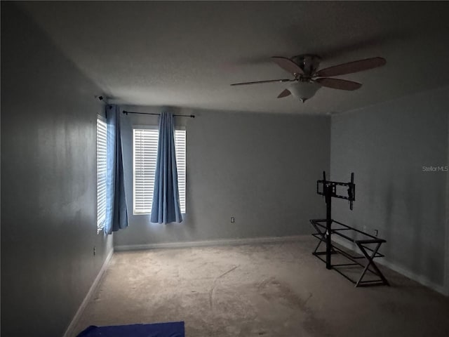 unfurnished room with a ceiling fan and baseboards