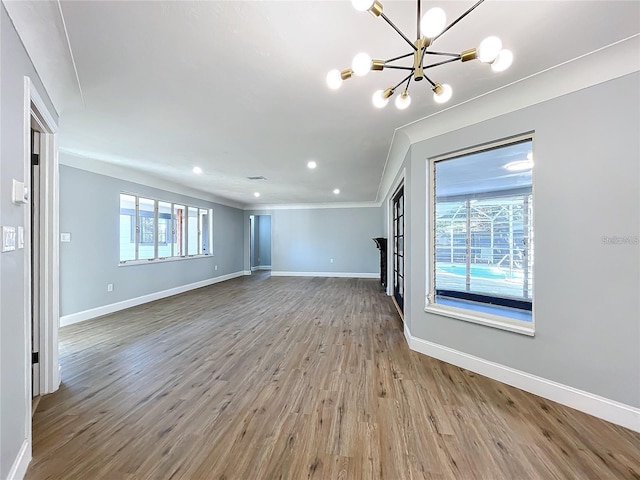 905 W 11th Ave, Mount Dora, FL 32757 - unfurnished living room featuring crown molding, a chandelier, wood finished floors, baseboards, and recessed lighting