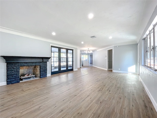 905 W 11th Ave, Mount Dora, FL 32757 - unfurnished living room featuring a chandelier, baseboards, crown molding, french doors, and light wood-style floors