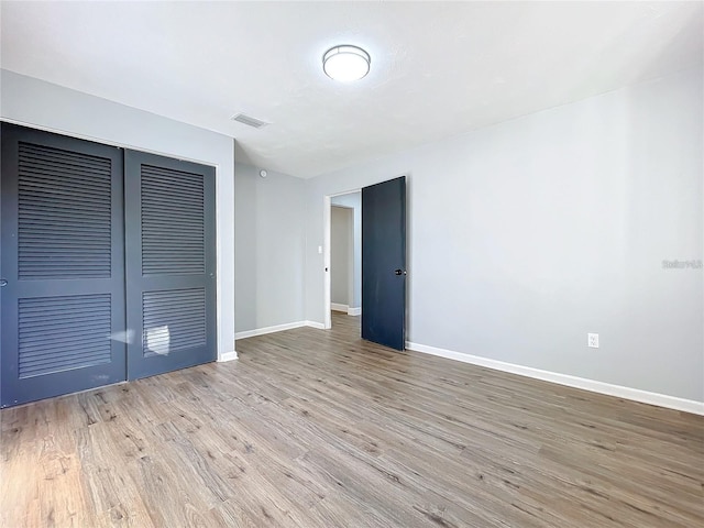905 W 11th Ave, Mount Dora, FL 32757 - unfurnished bedroom featuring baseboards, wood finished floors, and a closet