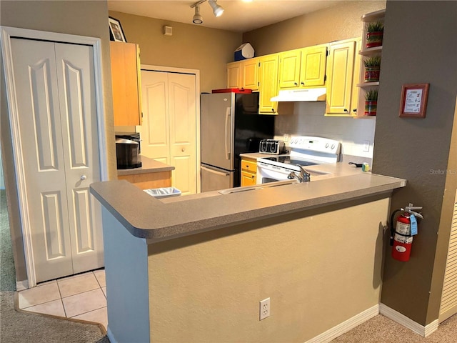 8809 Dunes Ct Unit 201, Kissimmee, FL 34747 - kitchen featuring white range with electric cooktop, under cabinet range hood, freestanding refrigerator, open shelves, and a peninsula