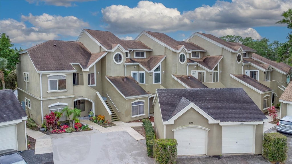 2662 Emerald Lake Ct, Kissimmee, FL 34744 - exterior space with a residential view, an attached garage, stucco siding, and roof with shingles