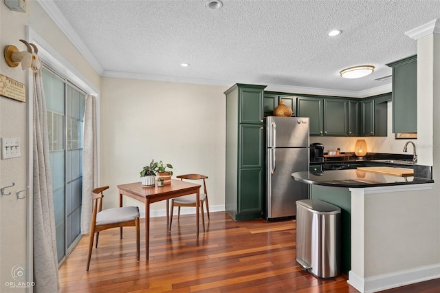4820 Conway Rd Unit 130, Orlando, FL 32812 - kitchen with green cabinetry, freestanding refrigerator, dark countertops, a textured ceiling, and dark wood-type flooring