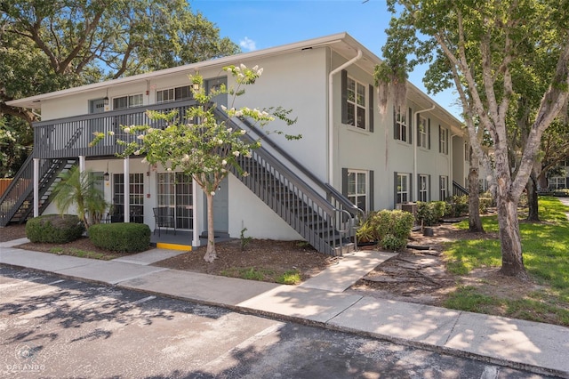 4820 Conway Rd Unit 130, Orlando, FL 32812 - view of front of home with stairway, stucco siding, and a deck