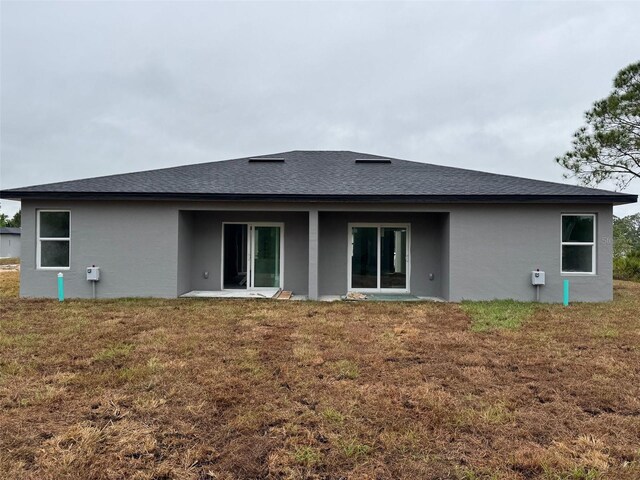 6935 Dickinson Dr, Sebring, FL 33872 - back of property featuring a lawn, a shingled roof, and stucco siding