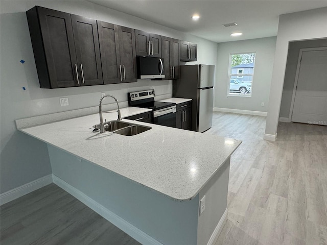 6935 Dickinson Dr, Sebring, FL 33872 - kitchen with light wood finished floors, a peninsula, a sink, visible vents, and appliances with stainless steel finishes