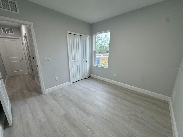 6935 Dickinson Dr, Sebring, FL 33872 - unfurnished bedroom featuring baseboards, visible vents, light wood-style floors, and a closet