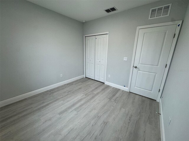 6935 Dickinson Dr, Sebring, FL 33872 - unfurnished bedroom with a closet, wood finished floors, visible vents, and baseboards