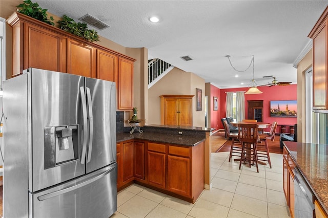 2005 Pitch Way, Kissimmee, FL 34746 - kitchen with brown cabinetry, visible vents, a peninsula, appliances with stainless steel finishes, and light tile patterned floors