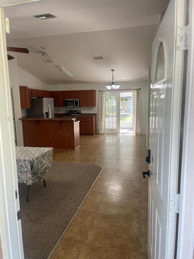 kitchen featuring a peninsula, visible vents, open floor plan, and appliances with stainless steel finishes