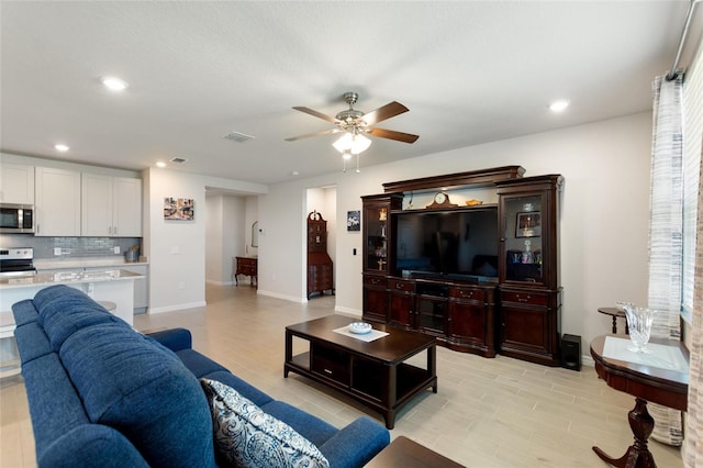 living area with recessed lighting, ceiling fan, baseboards, and visible vents