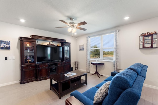 living room with a ceiling fan, light wood-style flooring, recessed lighting, and baseboards