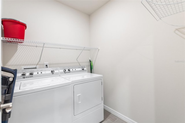 clothes washing area with washer and dryer, laundry area, and baseboards